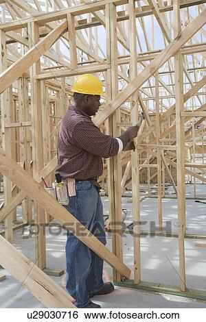 Construction worker hammering framework View Large Photo Image Stock Photograph - Construction worker hammering framework. Fotosearch