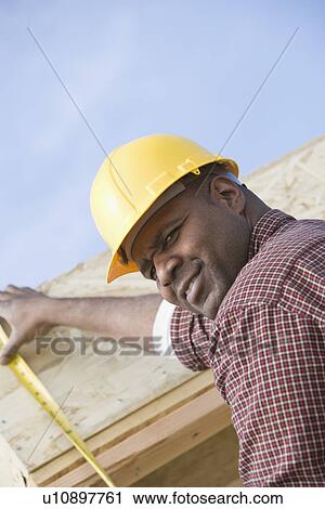 Construction worker measuring building View Large Photo Image Stock Image - Construction worker measuring building. Fotosearch
