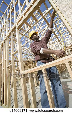 Construction worker measuring building View Large Photo Image Stock Image - Construction worker measuring building. Fotosearch