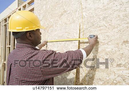 Construction worker measuring building View Large Photo Image Stock Image - Construction worker measuring building. Fotosearch