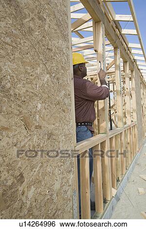 Construction worker measuring building View Large Photo Image Stock Photograph - Construction worker measuring building. Fotosearch