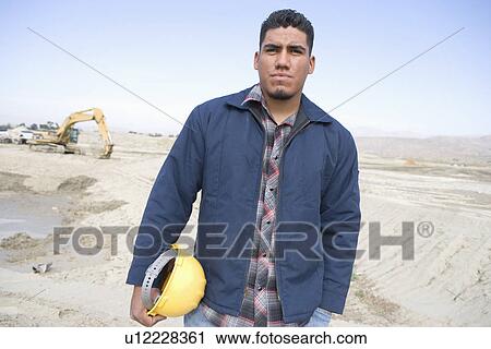 Stock Image - Construction worker on site, portrait. Fotosearch