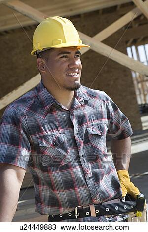 Stock Image - Construction worker standing on construction site. Fotosearch