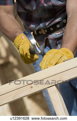Stock Photo - Construction worker using hammer, close-up. Fotosearch