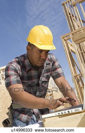 Construction worker using laptop View Large Photo Image Stock Image - Construction worker using laptop. Fotosearch