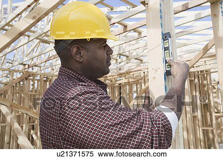 Construction worker using spirit level on building View Large Photo Image Stock Photography - Construction worker using spirit level on building. Fotosearch