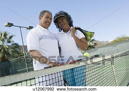 Stock Image - Couple at tennis court portrait. Fotosearch