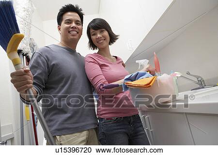 Stock Image - Couple doing housework, portrait. Fotosearch