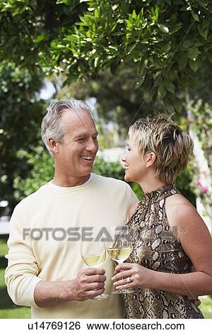 Stock Photograph - Couple drinking wine in garden. Fotosearch