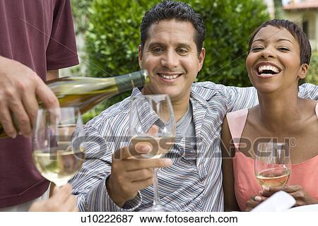 Couple drinking wine with friends outdoors View Large Photo Image Stock Photo - Couple drinking wine with friends outdoors. Fotosearch