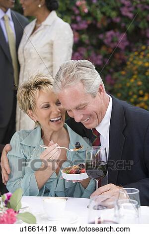 Stock Photo - Couple eating at outdoor table. Fotosearch