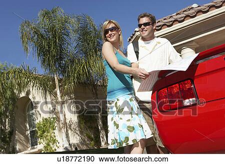 Couple looking at map by car outside house, low angle view View Large Photo Image Stock Image - Couple looking at map by car outside house, low angle view. Fotosearch