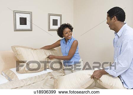 Couple making a bed together View Large Photo Image Stock Photo - Couple making a bed together. Fotosearch