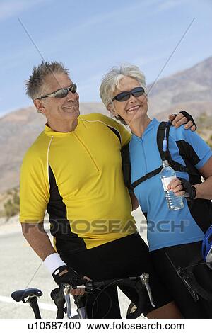 Stock Image - Couple on bicycle ride, portrait. Fotosearch