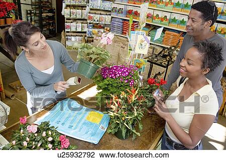 Stock Image - Couple purchasing plants in shop. Fotosearch