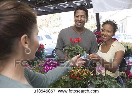 Stock Photo - Couple purchasing plants in shop. Fotosearch