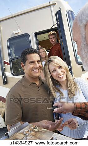 Stock Photo - Couple receiving keys to RV, portrait. Fotosearch