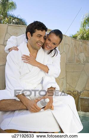 Couple relaxing by swimming pool View Large Photo Image Stock Image - Couple relaxing by swimming pool. Fotosearch