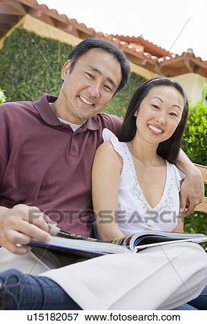 Stock Photo - Couple relaxing in back yard, portrait. Fotosearch