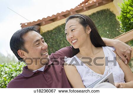 Stock Photo - Couple relaxing in back yard. Fotosearch