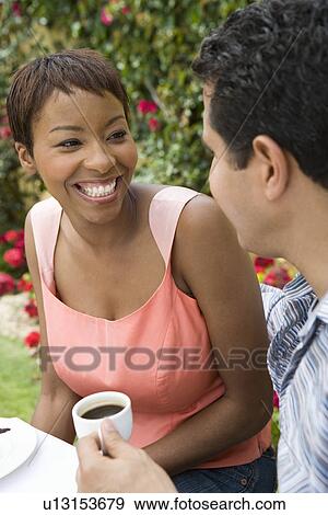 Couple relaxing with drinks outdoors View Large Photo Image Stock Photo - Couple relaxing with drinks outdoors. Fotosearch