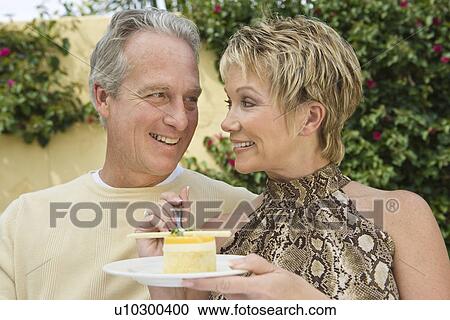 Stock Image - Couple sharing dessert outdoors. Fotosearch