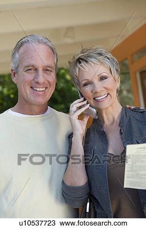 Stock Image - Couple smiling outdoors, portrait. Fotosearch