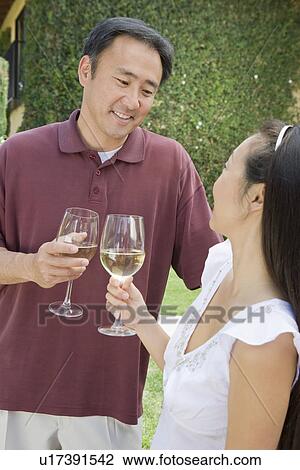 Stock Image - Couple toasting in garden. Fotosearch