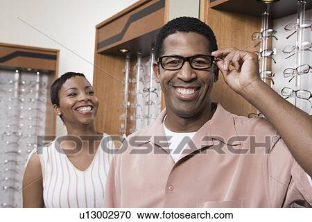 Couple trying on eyeglasses in store View Large Photo Image Stock Image - Couple trying on eyeglasses in store. Fotosearch