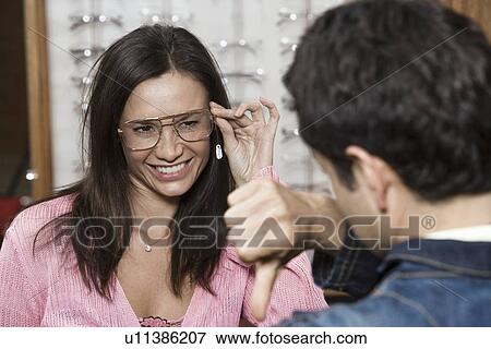 Couple trying on eyeglasses in store View Large Photo Image Stock Photo - Couple trying on eyeglasses in store. Fotosearch