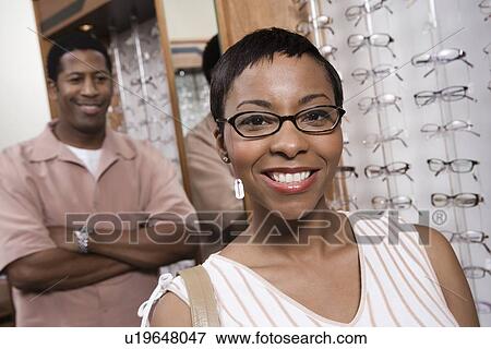 Couple trying on eyeglasses in store View Large Photo Image Stock Photo - Couple trying on eyeglasses in store. Fotosearch