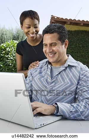 Couple using laptop in back yard View Large Photo Image Stock Image - Couple using laptop in back yard. Fotosearch