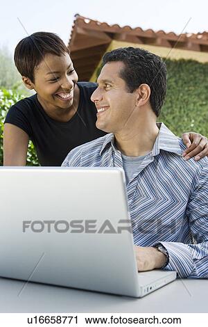 Couple using laptop in back yard View Large Photo Image Stock Image - Couple using laptop in back yard. Fotosearch