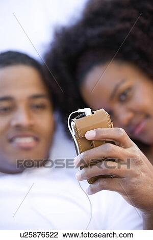 Stock Image - Couple Using MP3 Player. Fotosearch