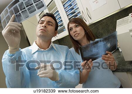 Stock Photo - Dentist and hygienist examining X-rays in laboratory. Fotosearch