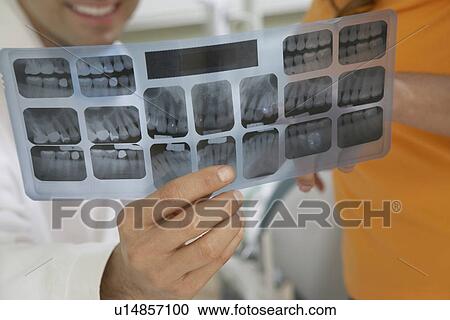 Dentist and patient examining X-rays, (close-up) View Large Photo Image Stock Image - Dentist and patient examining X-rays, (close-up). Fotosearch