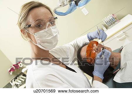 Dentist examining female patient in surgery, (portrait) View Large Photo Image Stock Photo - Dentist examining female patient in surgery, (portrait). Fotosearch