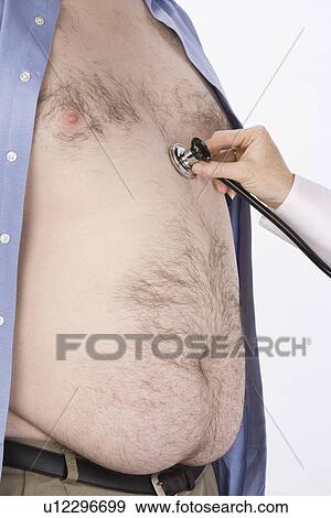 Stock Photo - Doctor hand with stethoscope on overweight man's heart,, mid section. Fotosearch