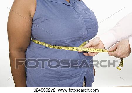 Doctor taking measures of overweight mid-adult woman View Large Photo Image Stock Image - Doctor taking measures of overweight mid-adult woman. Fotosearch