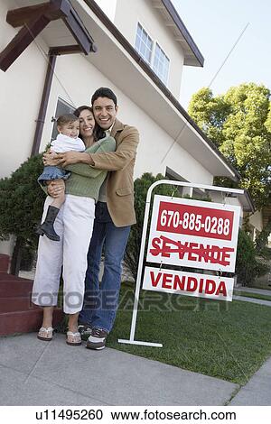 Family standing in front of house with For Sale sign, portrait View Large Photo Image Stock Image - Family standing in front of house with For Sale sign, portrait. Fotosearch