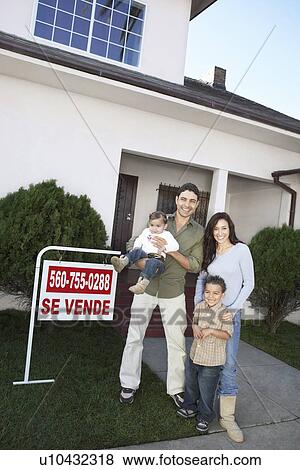 Family standing in front of house with For Sale sign, portrait View Large Photo Image Stock Photo - Family standing in front of house with For Sale sign, portrait. Fotosearch
