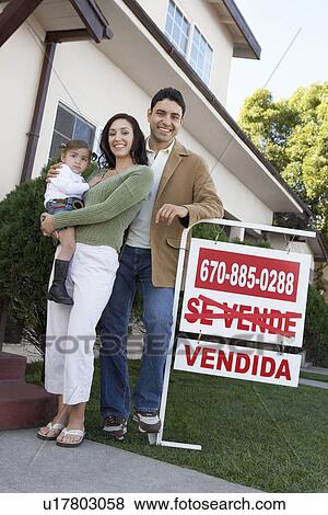 Family standing in front of house with For Sale sign, portrait View Large Photo Image Stock Photo - Family standing in front of house with For Sale sign, portrait. Fotosearch