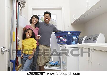 Family with daughter (7-9) doing laundry, portrait View Large Photo Image Stock Photo - Family with daughter (7-9) doing laundry, portrait. Fotosearch