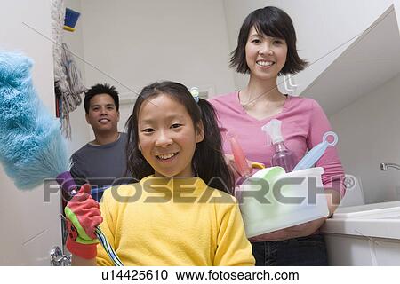 Stock Image - Family with girl (10-12) doing housework. Fotosearch