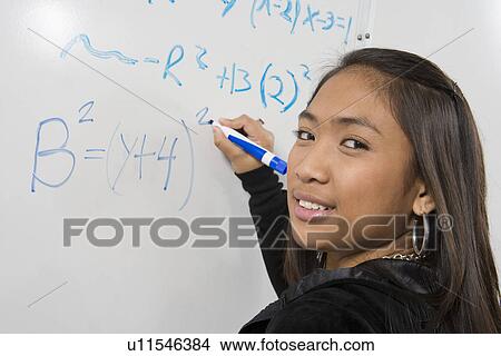 Female student writing maths equations on whiteboard View Large Photo Image Picture - Female student writing maths equations on whiteboard. Fotosearch