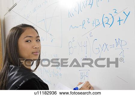 Female student writing maths equations on whiteboard View Large Photo Image Stock Photograph - Female student writing maths equations on whiteboard. Fotosearch