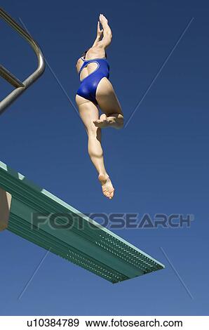 Stock Photo - Female swimmer jumping on diving boards. Fotosearch