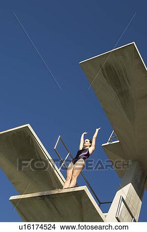 Picture - Female swimmer standing on diving board. Fotosearch