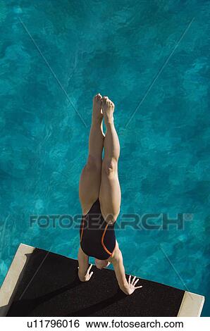 Stock Photograph - Female swimmer standing on hands on Diving Board. Fotosearch