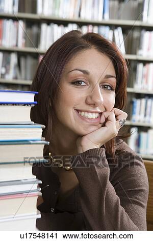Stock Image - Female University student in library, portrait. Fotosearch